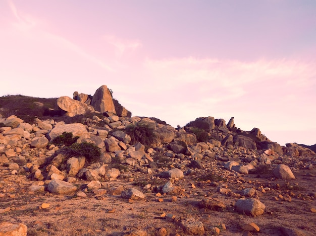 Hermoso y dramático cielo de puesta de sol rosa azul oscuro con nubes sobre las montañas de piedra de roca