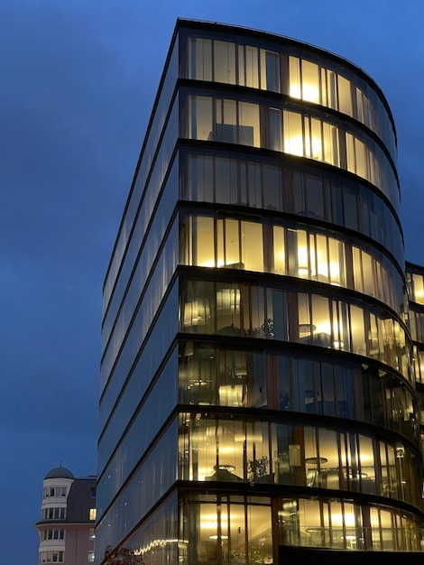 Hermoso edificio corporativo de varios pisos con ventanas que brillan al atardecer