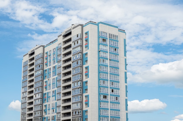 Hermoso edificio residencial nuevo y moderno. Pared coloreada en el fondo del cielo azul. Copie el espacio.