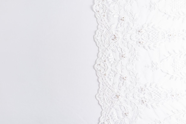 Hermoso encaje con cuentas y lentejuelas en el lado derecho del fondo de satén blanco Diseño para un álbum de fotos de boda invitaciones postales