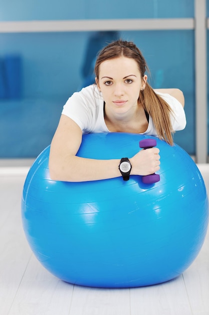 hermoso entrenamiento de fitness de mujer joven con pesas en el club deportivo