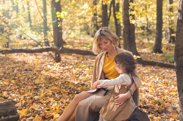 Hermoso estilo de vida otoño foto madre e hijo paseos por la noche en el cálido sol del parque