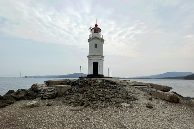 Hermoso faro solitario con montañas de fondo