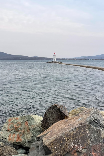 Hermoso faro solitario con montañas de fondo