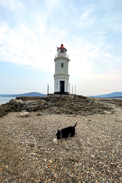 Hermoso faro solitario con montañas de fondo