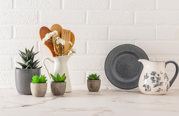 hermoso fondo de la cocina en tonos grises y blancos con utensilios de cocina y utenselios pared de ladrillo blanco en el interior moderno de la cocina