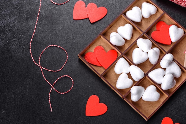 Hermoso fondo con corazones blancos y rojos sobre una mesa oscura. Preparándonos para el día de los enamorados