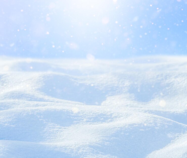 Hermoso fondo de invierno con ventisqueros, copos de nieve que caen suavemente contra el cielo azul.