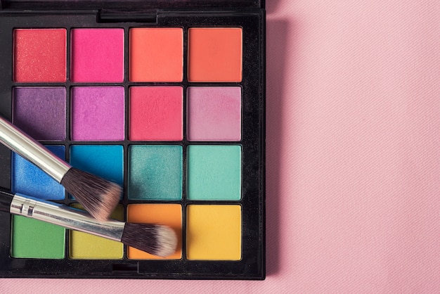 Hermoso fondo de maquillaje. Pincel de maquillaje en la paleta de colores de maquillaje con copyspace.