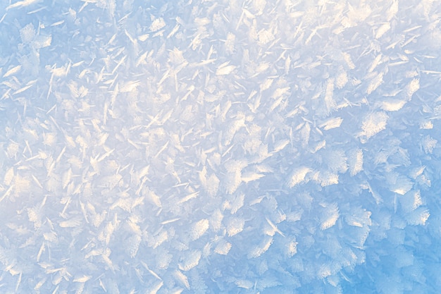Hermoso fondo natural de invierno degradado de cristales de hielo y nieve iluminados por el sol