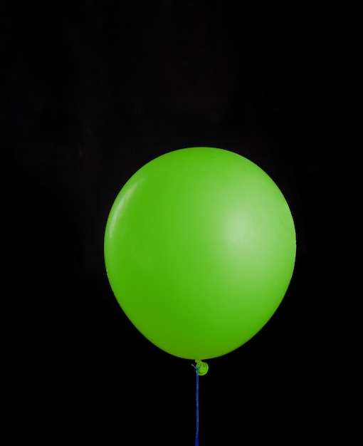 Hermoso globo verde sobre fondo negro aislado. Concepto de regalo de diseño