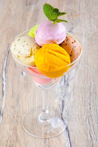 Hermoso helado en un recipiente transparente sobre un fondo de madera