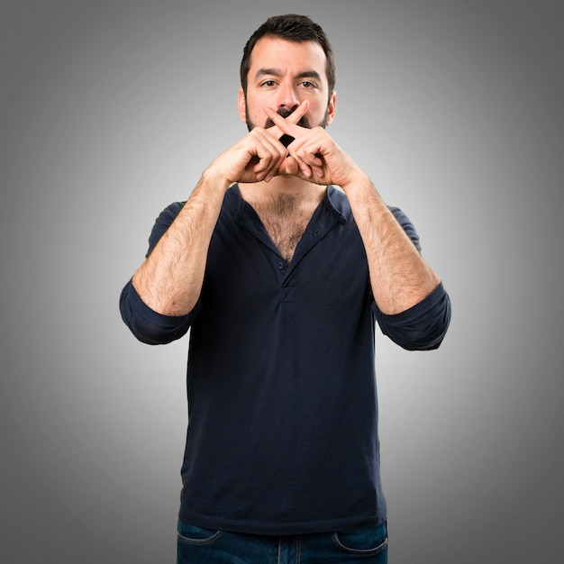 Foto hermoso hombre con barba haciendo silencio gesto sobre fondo gris