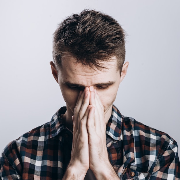 Hermoso hombre emocional aislado sobre fondo gris