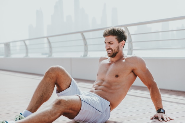 Hermoso hombre haciendo ejercicio y diferentes ejercicios al aire libre