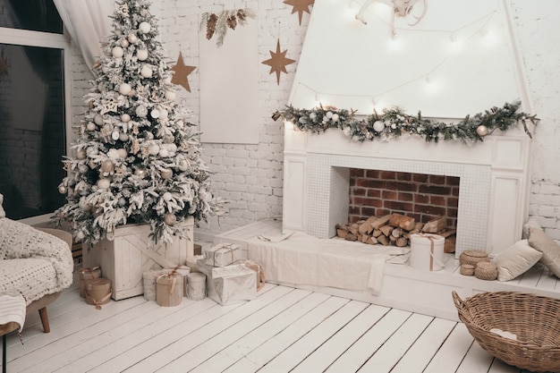 Hermoso interior de año nuevo escandinavo. Árbol de Navidad cerca de la chimenea. Regalos bajo el árbol de Navidad.