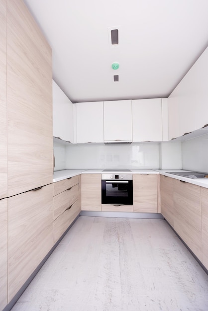 Hermoso interior de cocina moderno, luminoso y limpio en una nueva casa de lujo con armarios de madera