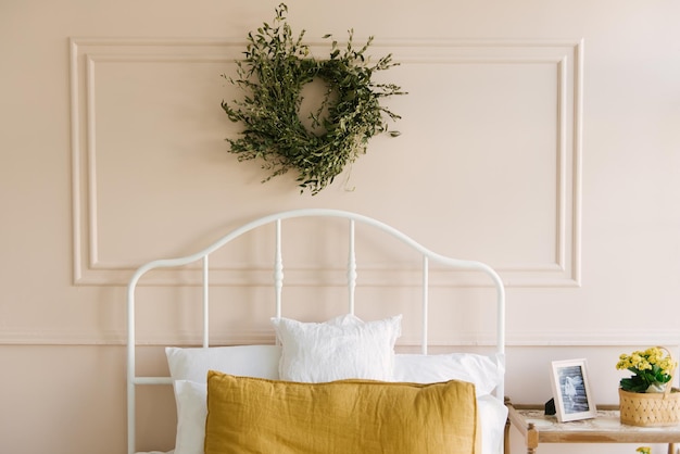 Hermoso interior elegante de un dormitorio luminoso con una cama blanca junto a la ventana y textiles