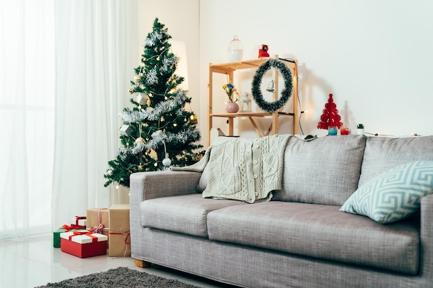 hermoso interior elegante de vacaciones de una sala de estar con árbol de navidad y regalos. acogedora habitación decorada con ambiente festivo.