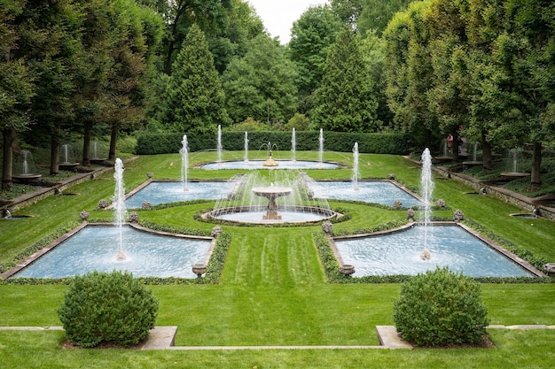 Hermoso jardín con fuentes y abundante vegetación en un día sombrío en Longwood USA