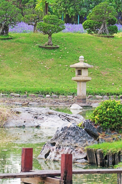 Hermoso jardín japonés con una linterna de piedra en el parque