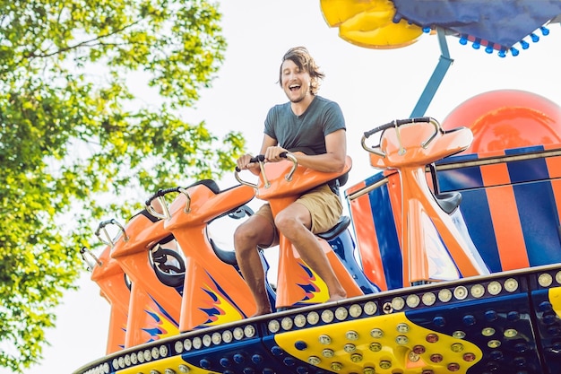 Hermoso, joven divirtiéndose en un parque de atracciones