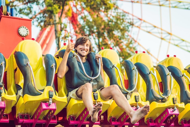 Hermoso, joven divirtiéndose en un parque de atracciones