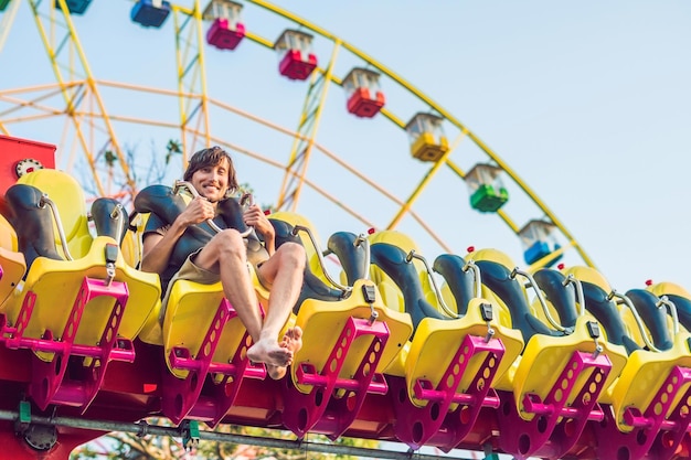 Hermoso, joven divirtiéndose en un parque de atracciones.