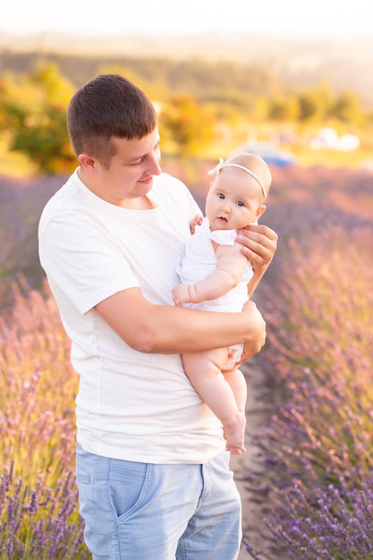 Hermoso joven padre con bebé en campo de lavanda