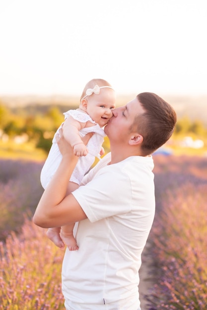 Hermoso joven padre con bebé en campo de lavanda