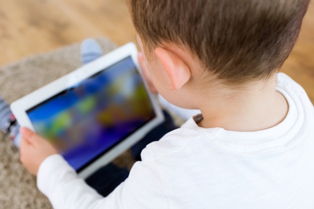 Hermoso joven utilizando su tableta digital en casa.