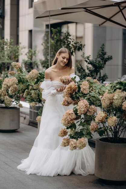 Hermoso joven con vestido de novia posando al aire libre