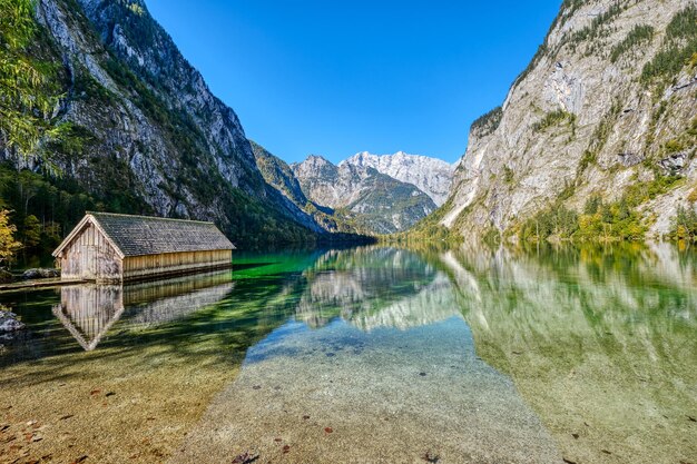 Foto el hermoso lago en los alpes bávaros con una casa de botes de madera