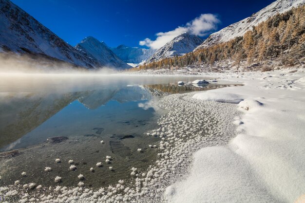 Hermoso lago de montaña al amanecer después de una nevada