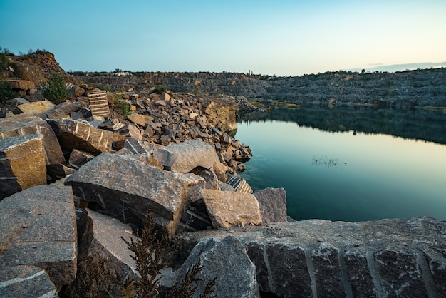 Un hermoso lago muy pequeño rodeado de grandes montones de piedra.