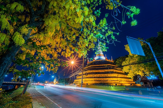 Hermoso Las luces en la carretera con flores amarillas Cassia Fistula en el parque en Phra Chedi Luang en el templo (Wat Ratchaburana) es un templo budista en Phitsanulok, Tailandia en el crepúsculo natural