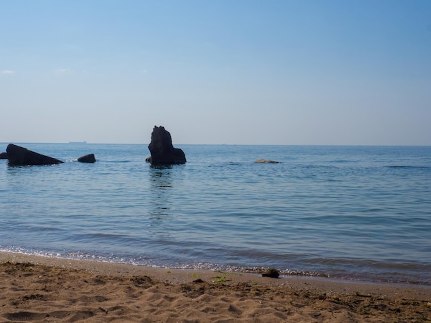 Hermoso mar al mediodía en verano, agua clara, playa de arena, olas silenciosas iluminadas por el paisaje marino del sol del mediodía en Ucrania