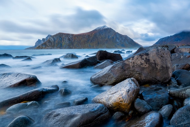 Hermoso mar azul con magnífica montaña en Lofoten en puesta de sol