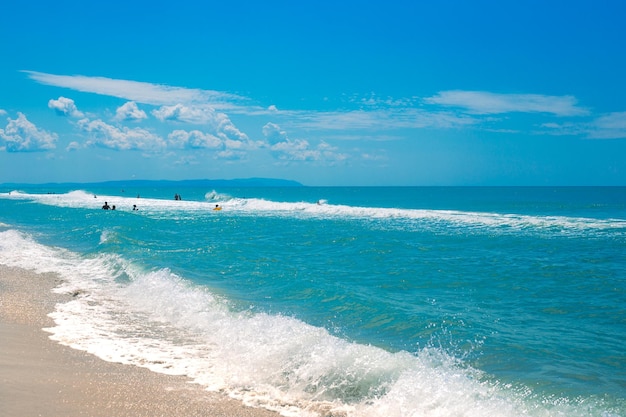 Hermoso mar azul con una ola y una orilla arenosa en un día soleado de verano Viajes y turismo