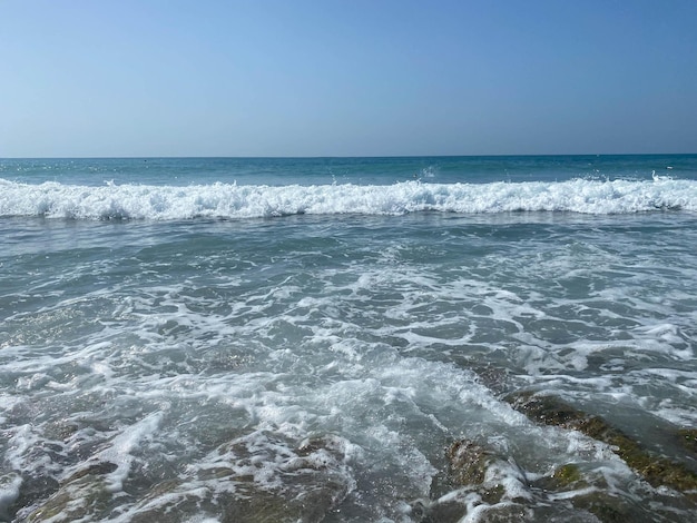 Hermoso mar con olas salpicando agua vista del paisaje desde la playa en un cálido este tropical