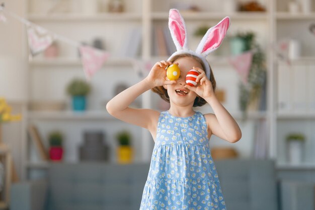 Hermoso niño pintando huevos Familia feliz preparándose para Pascua