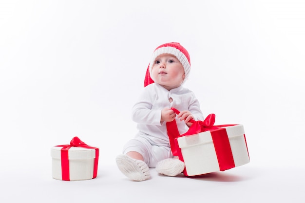 hermoso niño con regalos de navidad y gorro de santa claus