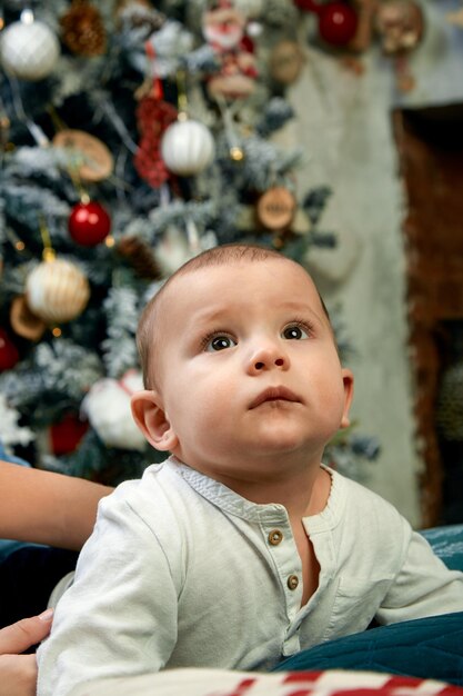 Hermoso niño soñando con cabañas bajo el árbol de Navidad Concepto de Navidad y niños esperando un milagro