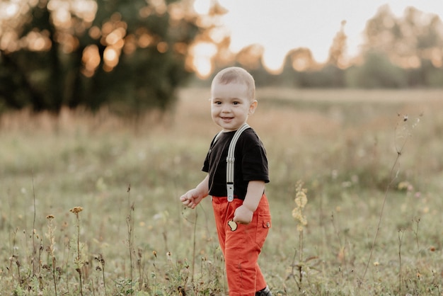 Hermoso niño sonriente caminando sobre hierba