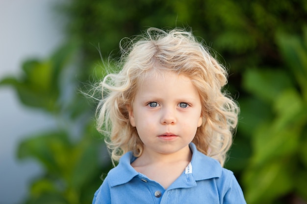 Hermoso niño de tres años con largo cabello rubio.