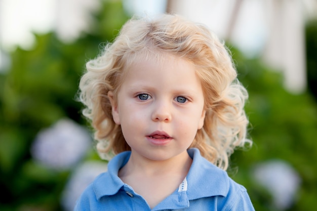 Hermoso niño de tres años con largo cabello rubio.