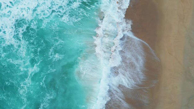 El hermoso océano aéreo espumando salpicando en la playa de arena el agua del mar tormentosa rodando