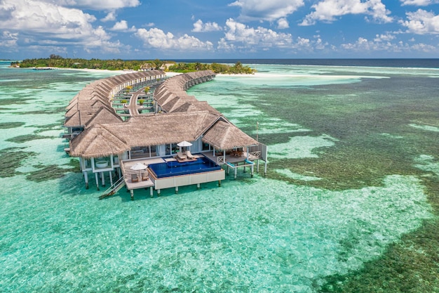 Hermoso paisaje aéreo, resort tropical de lujo con villas de agua y hermosa escena de playa