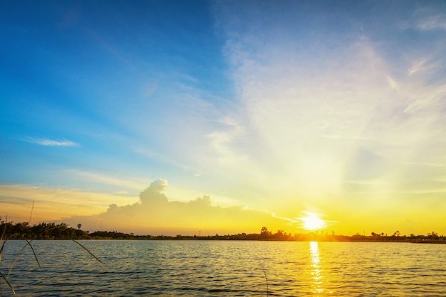 Hermoso paisaje del atardecer con cielo azul sobre el lago