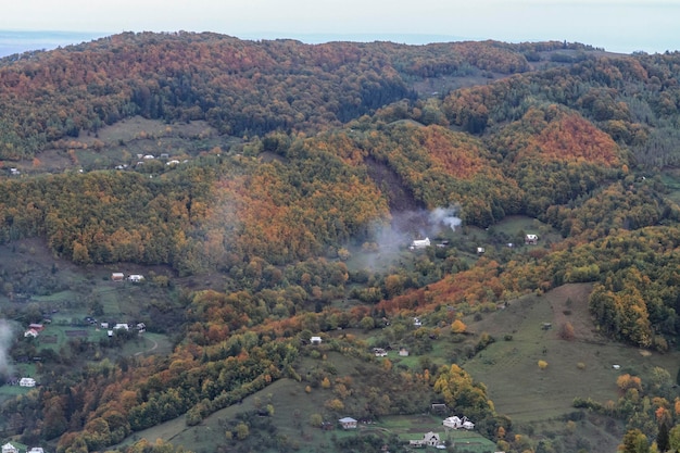 Hermoso paisaje de bosque otoñal con casas pequeñas vista aérea Senderismo Viajes Estilo de vida concepto montaña Vacaciones actividad viaje al aire libre en las montañas de los Cárpatos Ucrania